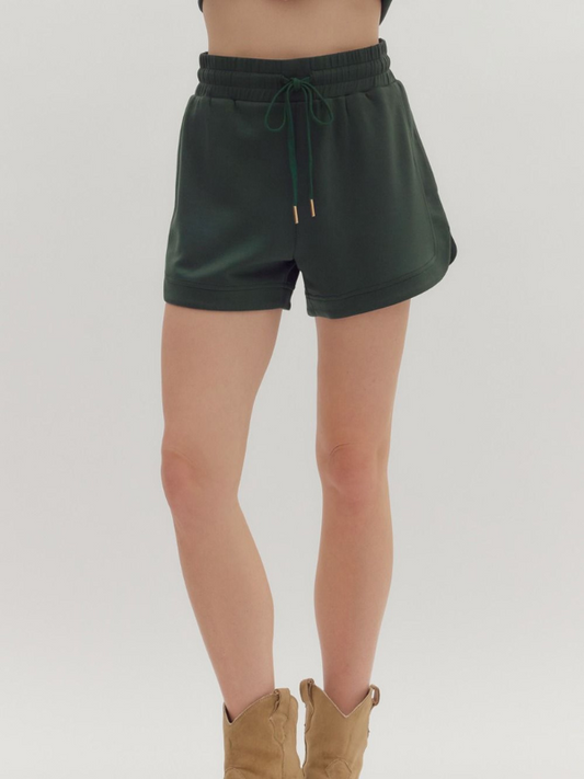 Green shorts worn by a person on a plain background
