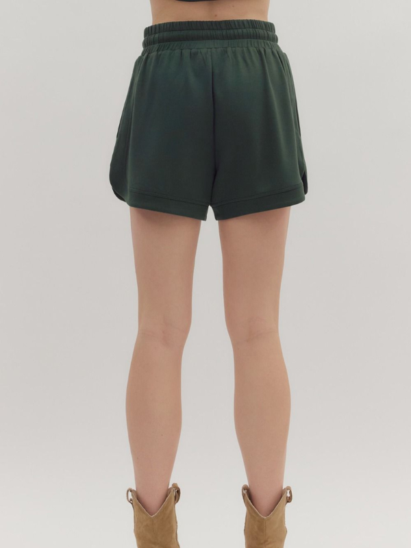 Green shorts worn by a person on a white background