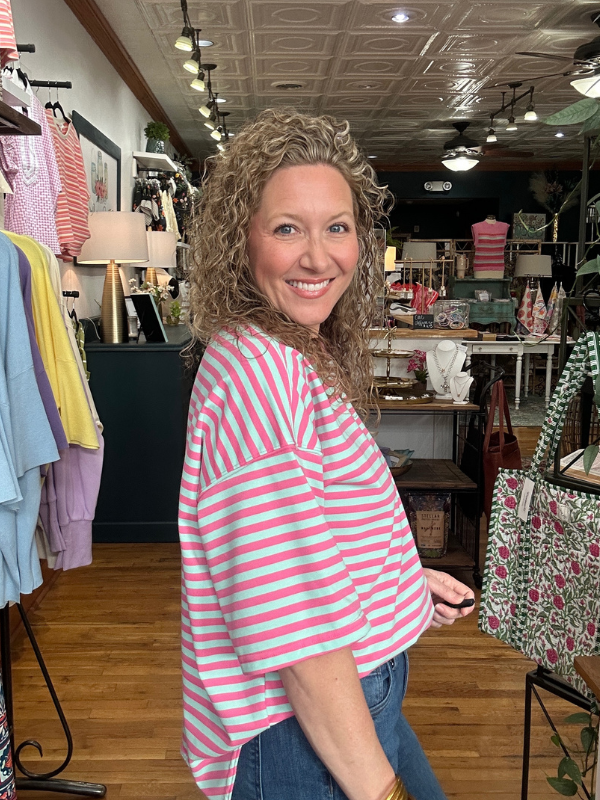 Woman wearing a pink and white striped shirt in a store setting
