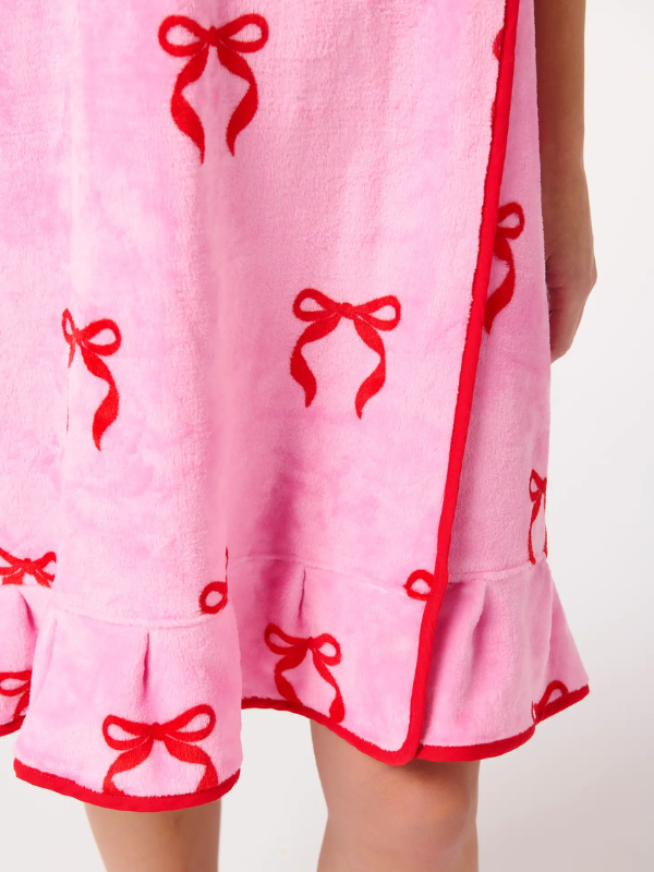 Pink dress with red bow patterns on a white background