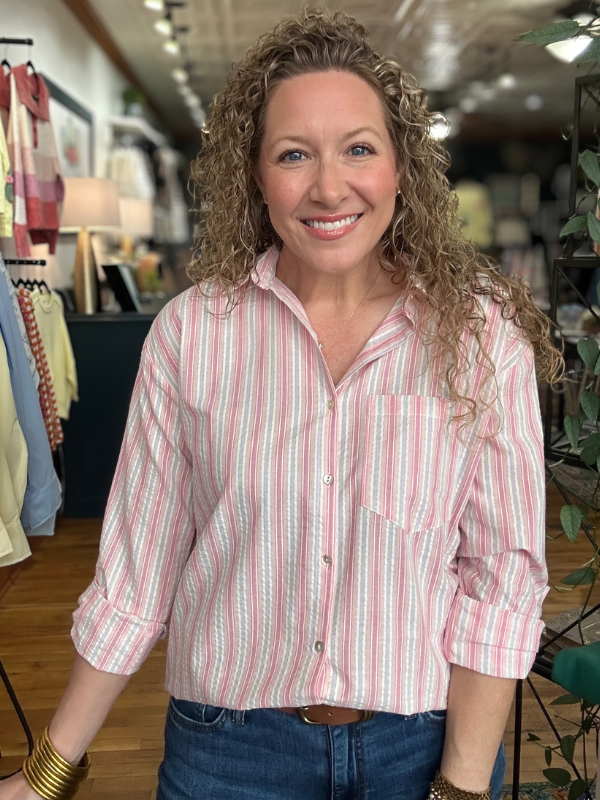 Woman wearing a pink and white striped shirt in a store setting
