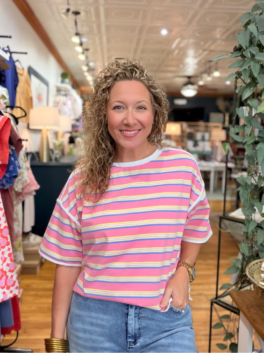 Woman wearing a colorful striped shirt in a store setting