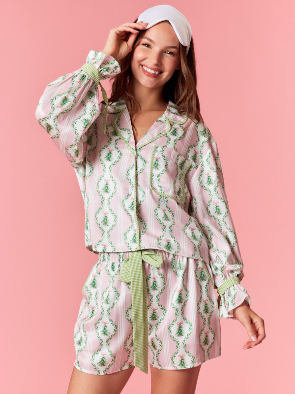 Woman wearing a floral pajama set with a pink background