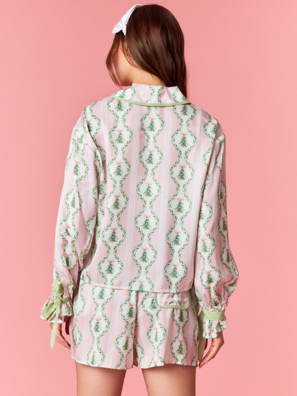 Person wearing a pink and green patterned outfit on a pink background