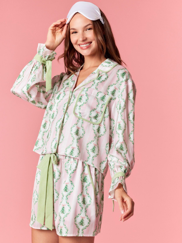Woman wearing a floral pajama set with a pink background