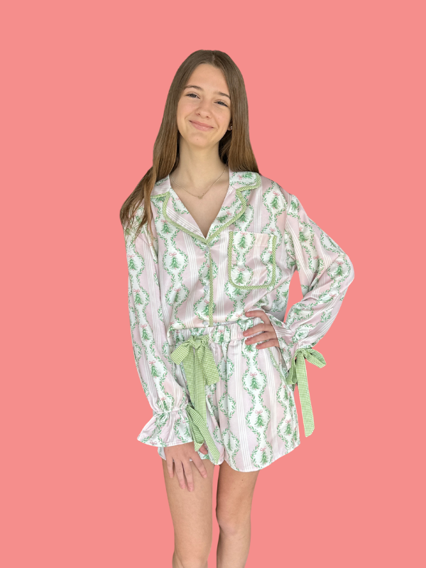 Woman wearing a patterned dress with green accents on a pink background
