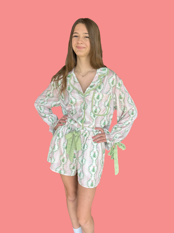Woman wearing a floral romper on a pink background