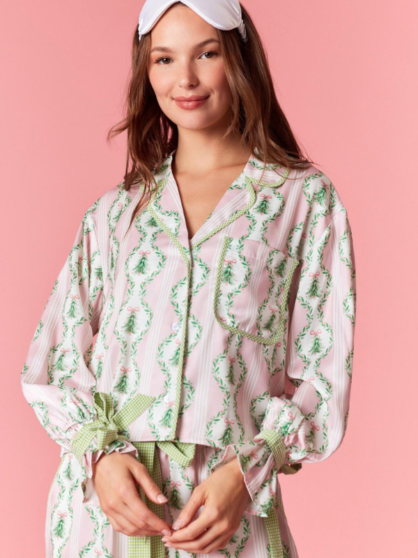 Woman wearing a pink floral robe against a pink background