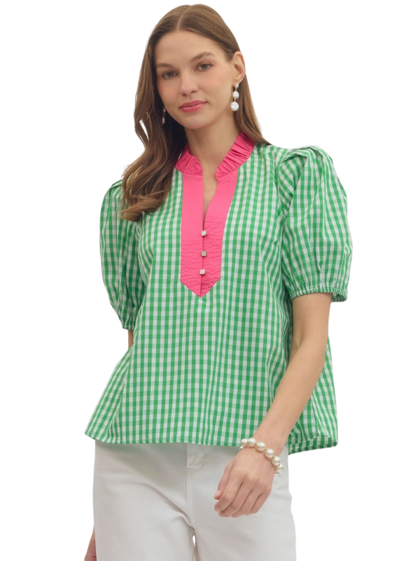 Woman wearing a green checkered blouse with pink trim on a white background