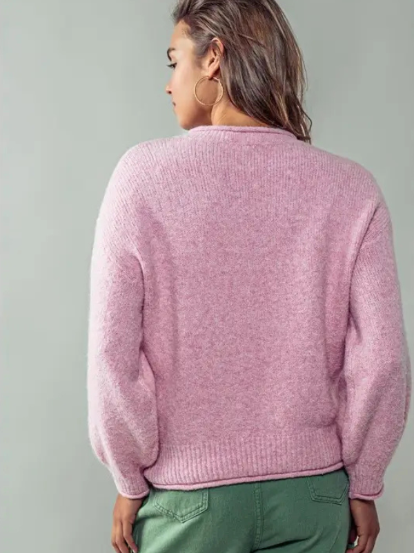 Person wearing a pink sweater against a gray background