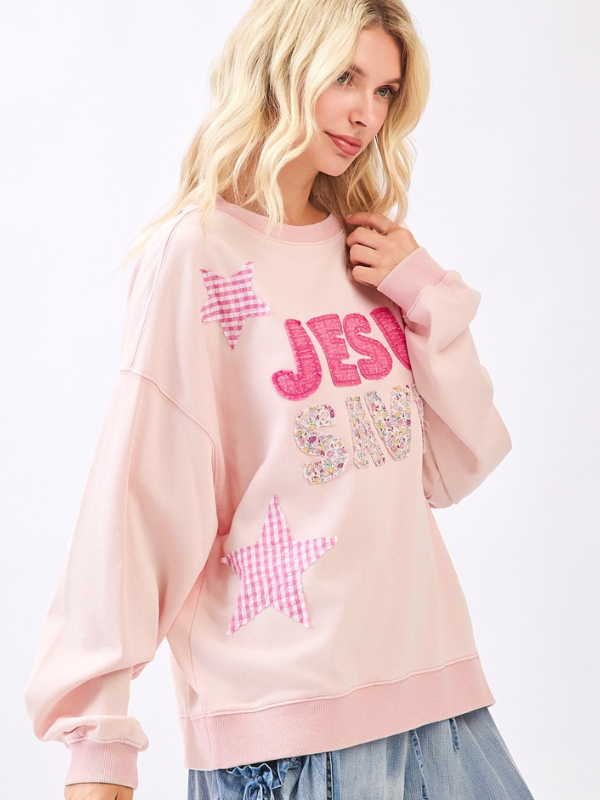 Woman wearing a pink sweatshirt with decorative elements on a white background