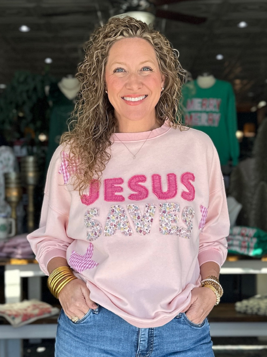 Woman wearing a pink sweatshirt with 'Jesus Saves' text in a store setting