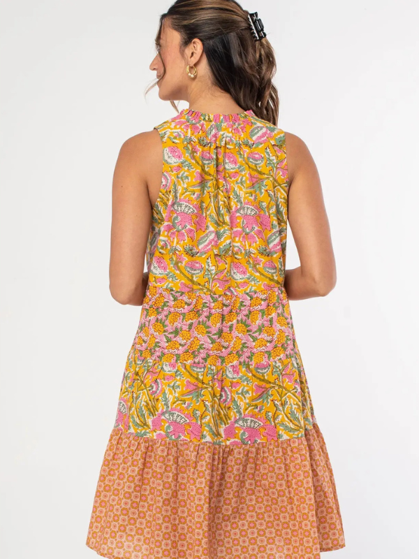 Woman wearing a sleeveless dress with a floral pattern on a white background