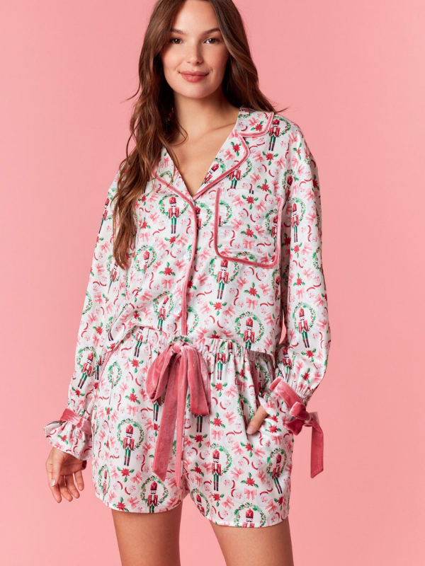 Woman wearing a floral pajama set against a pink background