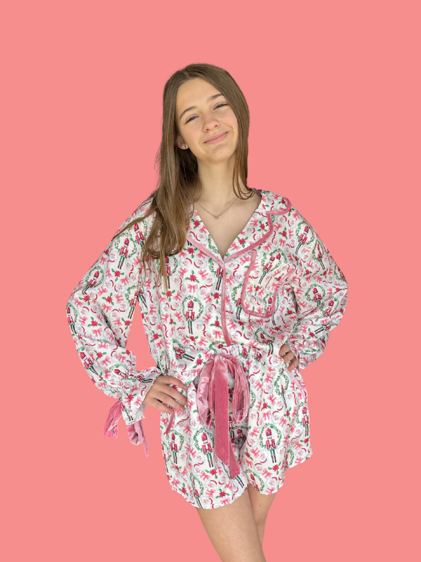Woman wearing a patterned pajama set against a pink background