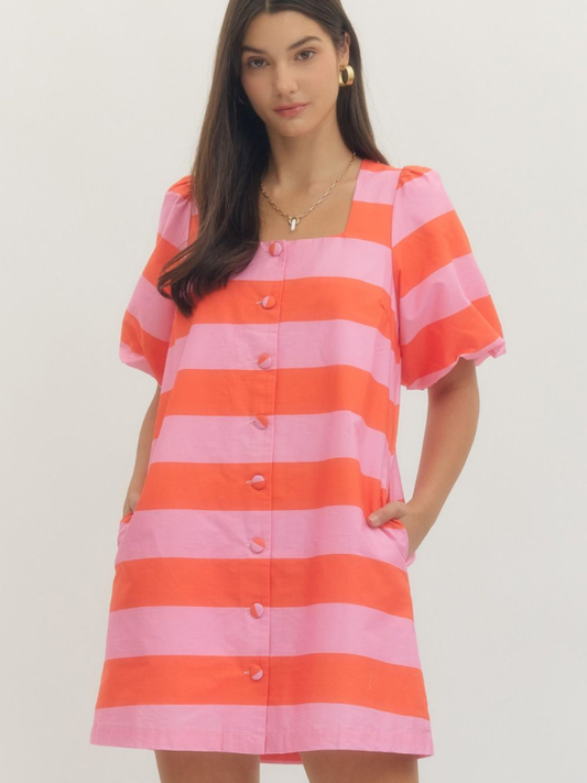 Woman wearing a pink and orange striped dress on a plain background
