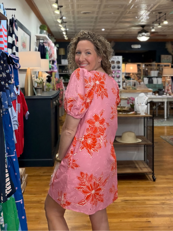 Woman wearing a pink floral dress in a store setting