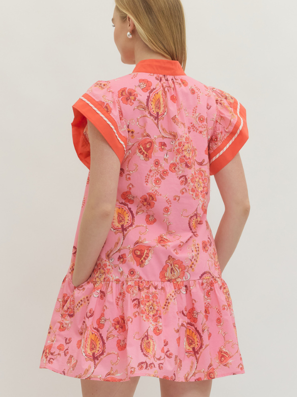 Pink floral dress with orange accents on a plain background