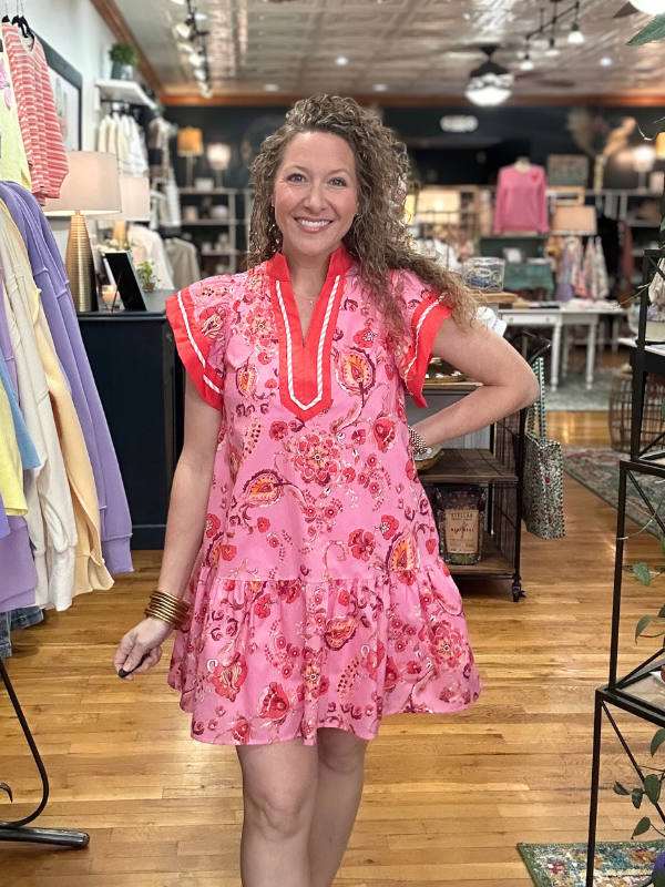 Woman wearing a pink floral dress in a store setting