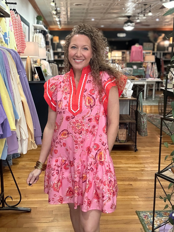 Woman wearing a pink floral dress in a clothing store