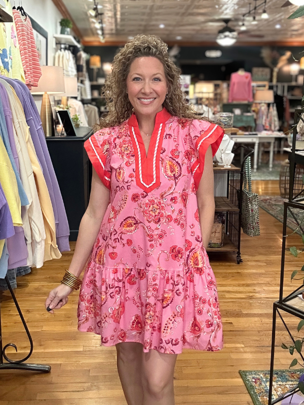 Woman wearing a pink floral dress in a store setting