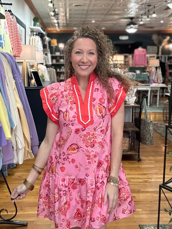 Woman wearing a pink floral dress in a store setting