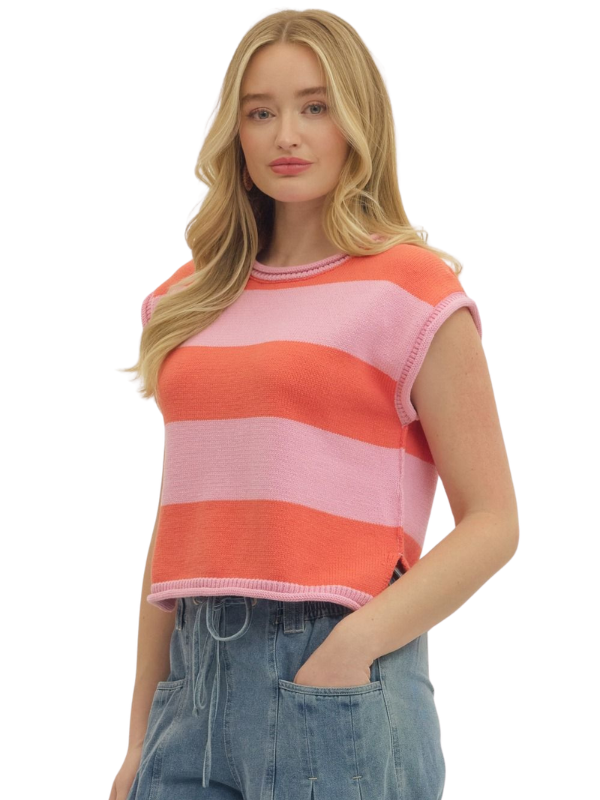 Woman wearing a pink and orange striped sleeveless top with blue jeans on a white background
