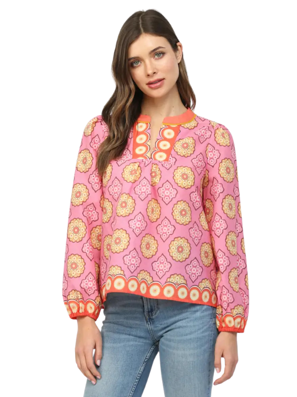 Woman wearing a pink floral blouse with blue jeans on a white background