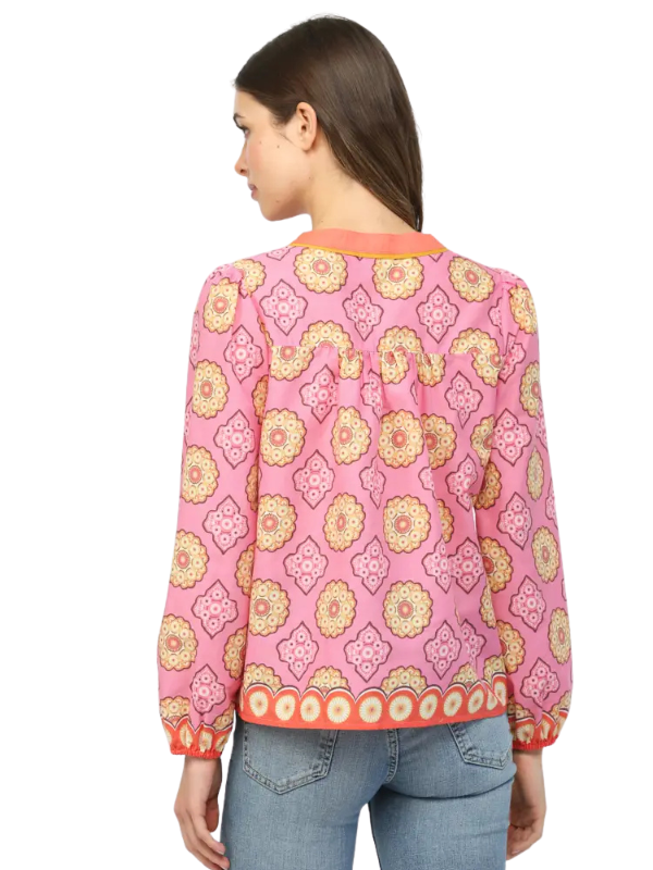 Woman wearing a pink patterned jacket on a white background