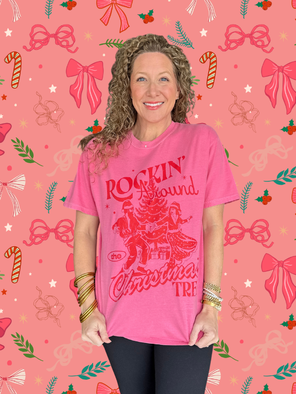 Woman wearing a pink t-shirt with Christmas-themed design on a festive background