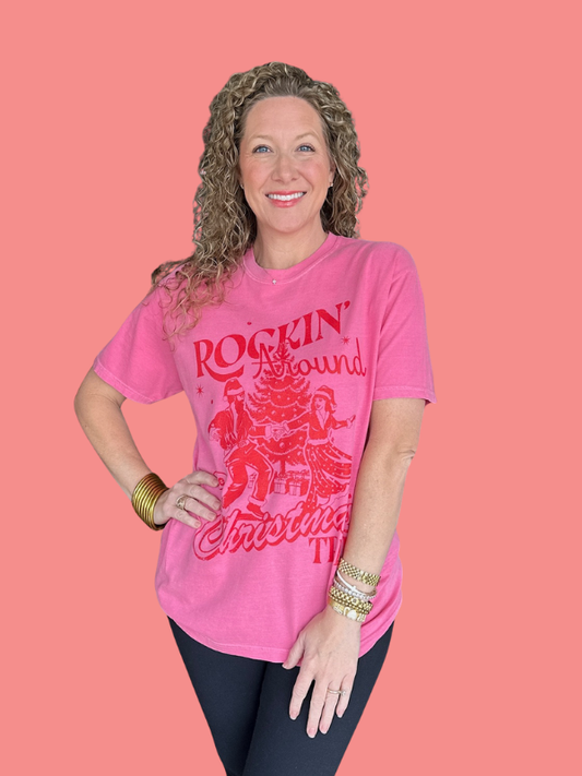 Woman wearing a pink t-shirt with red graphics and text on a pink background