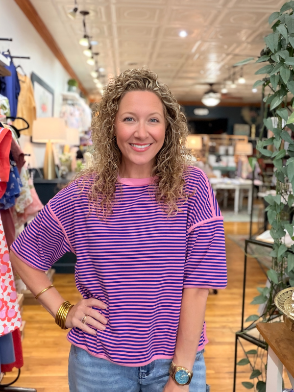 Woman wearing a purple striped shirt in a store setting