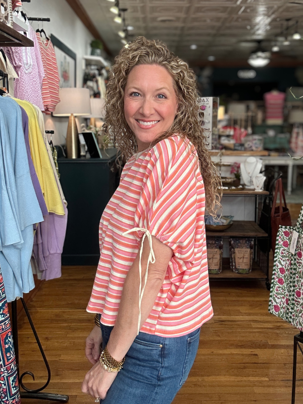 Woman in a striped shirt standing in a clothing store
