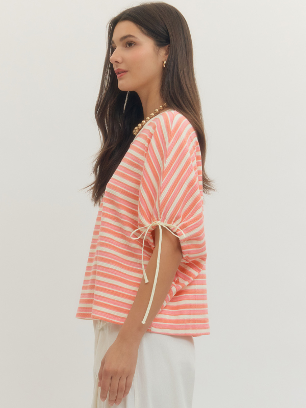 Woman wearing a striped top with a plain background