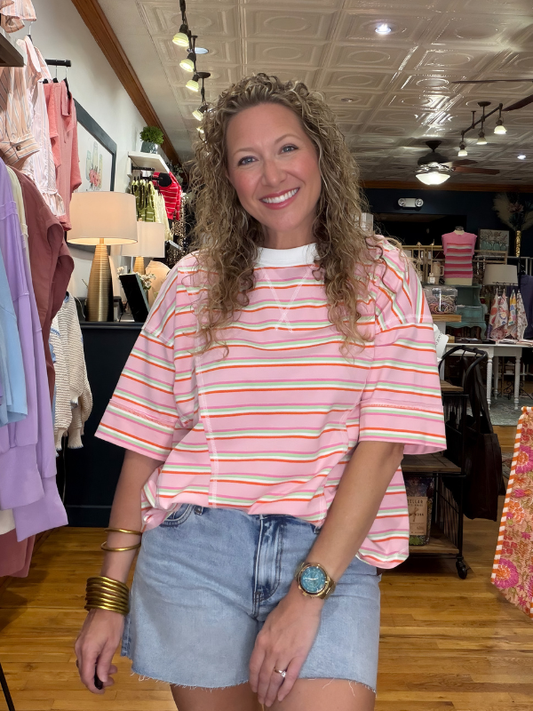 Woman wearing a striped shirt and denim shorts in a store setting