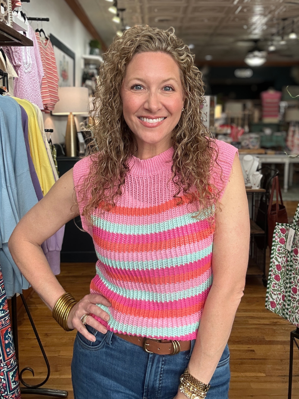 Woman wearing a colorful striped sleeveless top in a store setting