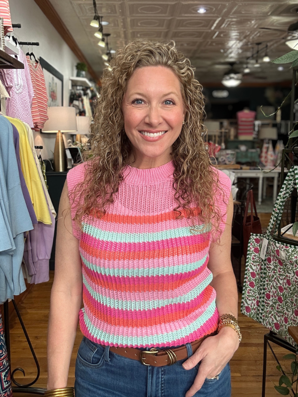 Woman wearing a colorful striped sleeveless top in a store setting