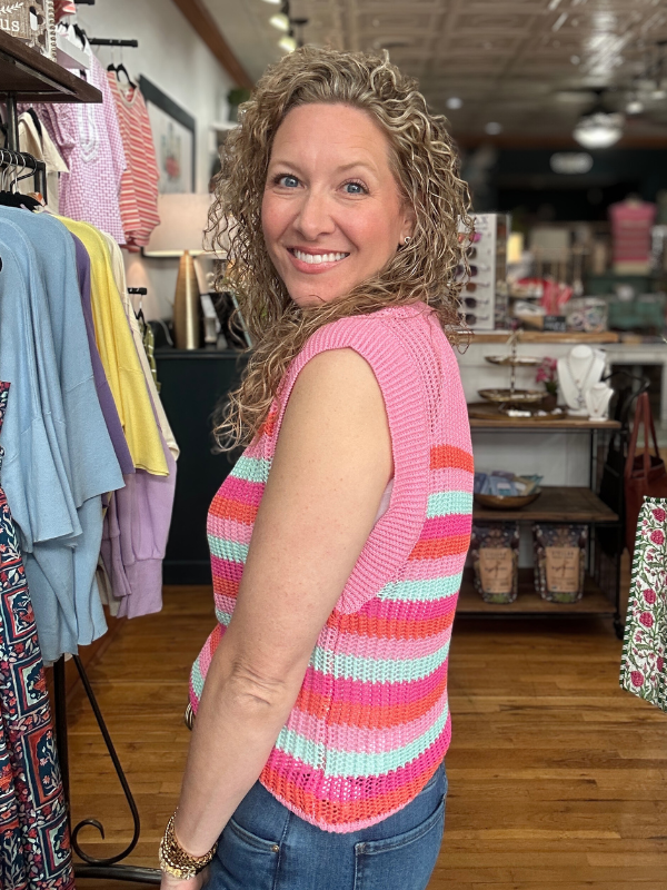 Woman wearing a colorful striped sleeveless top in a store setting