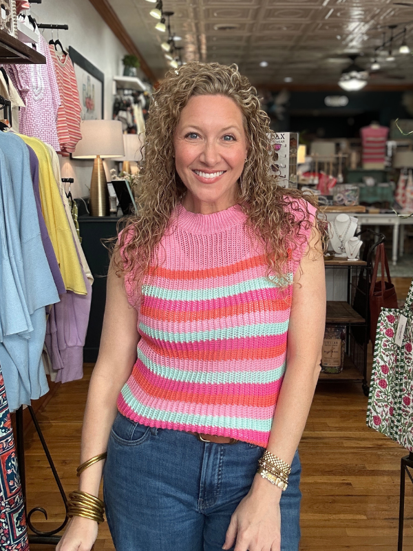 Woman wearing a colorful striped sweater in a clothing store