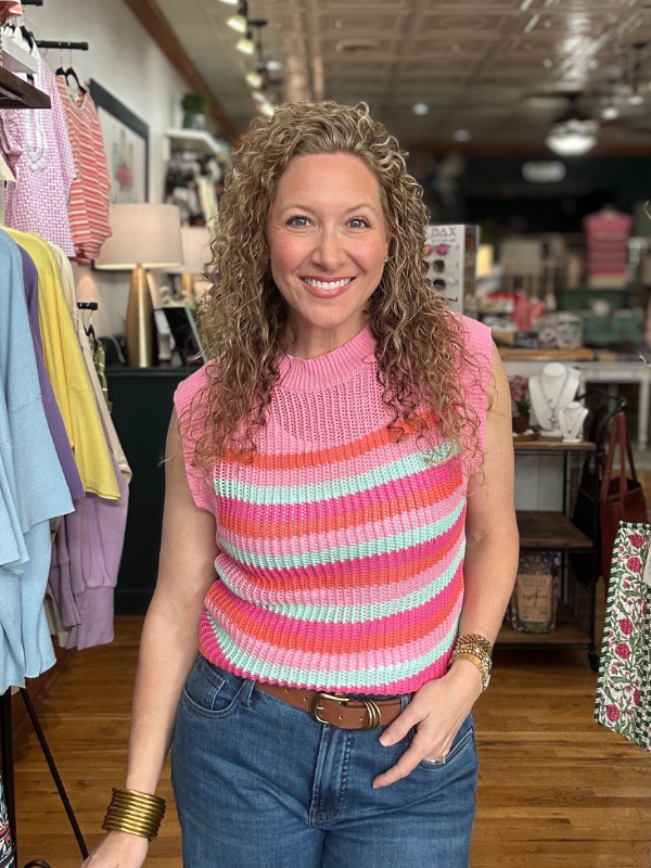 Woman wearing a colorful striped sleeveless top in a store setting