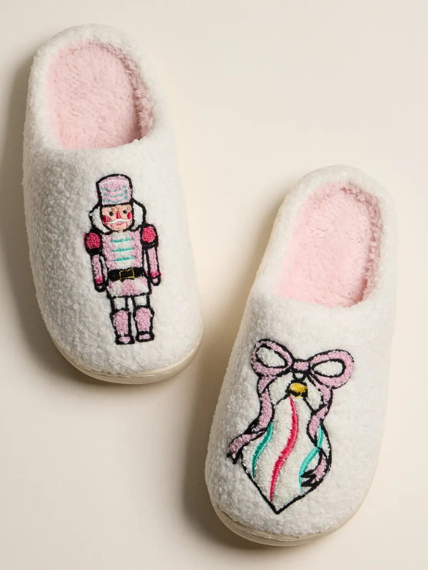 Pair of slippers with embroidered designs on a light background