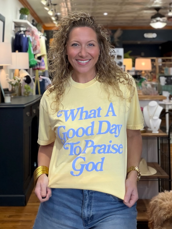 Woman wearing a yellow t-shirt with blue text in a store setting