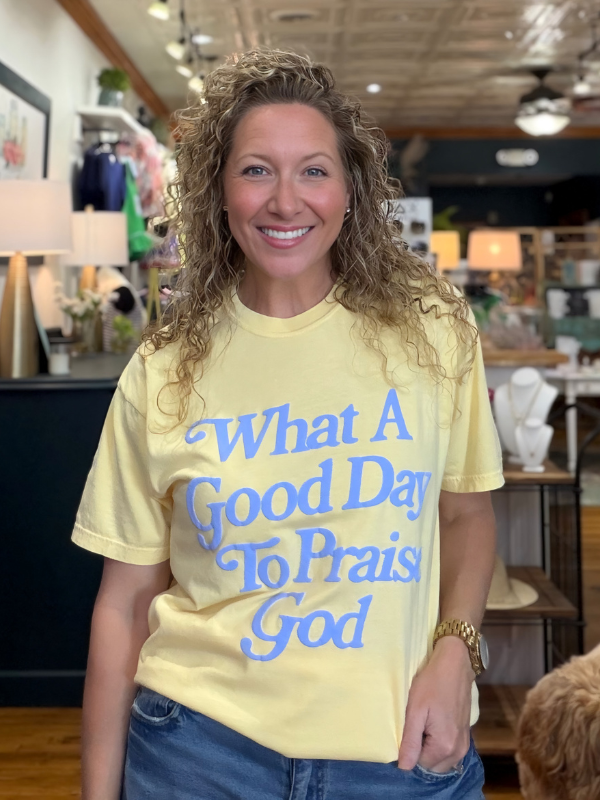 Woman wearing a yellow t-shirt with blue text in a store setting