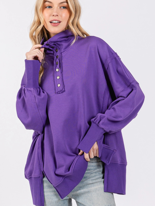 Woman wearing a purple oversized sweater with button details on a white background