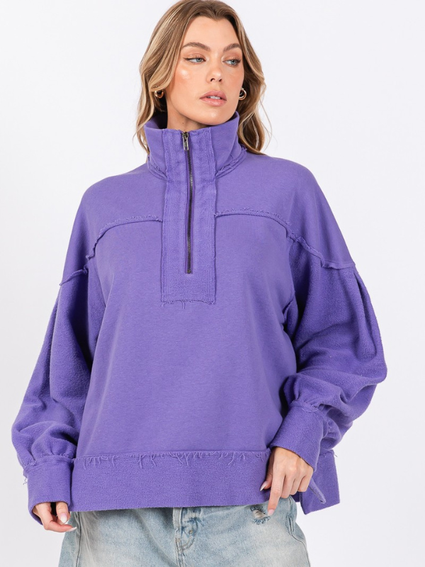 Woman wearing a purple pullover with a high collar on a white background