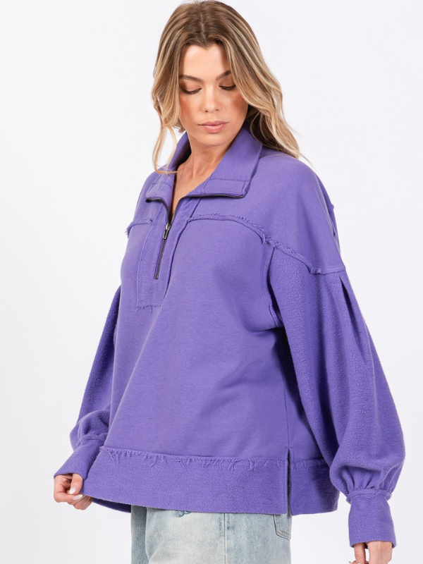 Woman wearing a purple pullover with a white background
