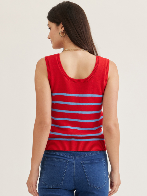 Woman wearing a red and blue striped sleeveless top on a beige background