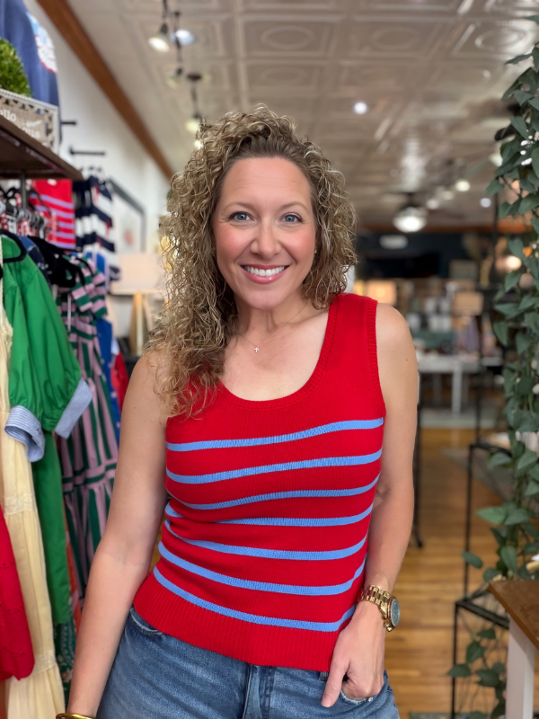 Woman wearing a red and blue striped tank top in a clothing store.