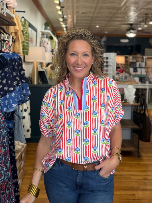 Woman wearing a red and white striped shirt with a floral pattern in a store setting
