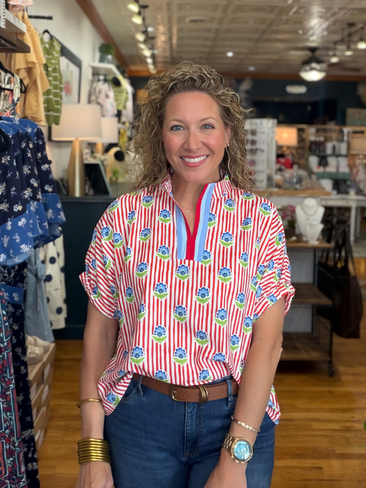 Woman wearing a colorful patterned shirt in a store setting